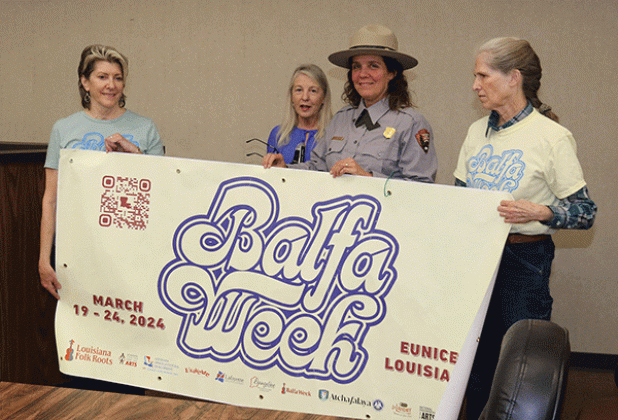 A banner for Balfa Week was shown at the Eunice Board of Aldermen’s meeting in December. From left, are Jean Johnson, Louisiana Folk Roots Board treasurer; Jeanne Solis, Folk Roots executive director; Angela Rathle, supervisory National Park Ranger; and Lorraine Shelton- Gaines, Folk Roots Board president. (Photo by Harlan Kirgan)