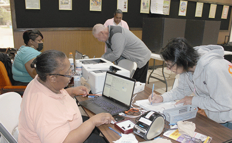 Charlene Papillion and Bertman Papillion of Swords cast their votes at Eunice City Hall during early voting Wednesday morning. Also shown are Commissioners Cynthia Martin and Alexis Gallien. Voting in the front page photo is Eveline Ardoin. (Photo by Myra Miller)