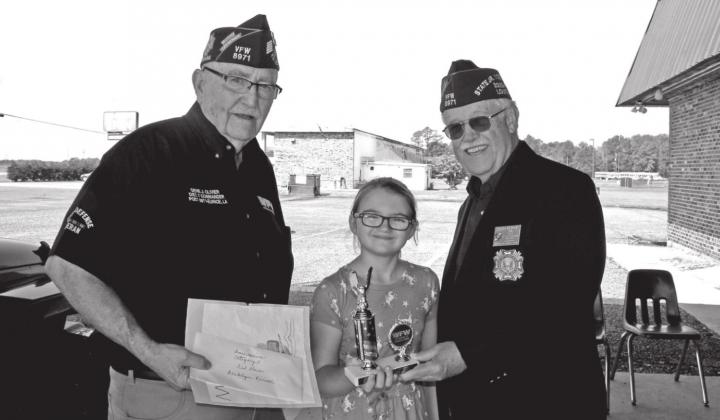 Blakelynn Pierrottie, a fourth grader at East Elementary, won third place with her participation of the VFW and Auxiliary sponsored Americanism contest. From left, are Gene Olivier, Pierrottie, and Don Reber, commander of the VFW Post 8971.
