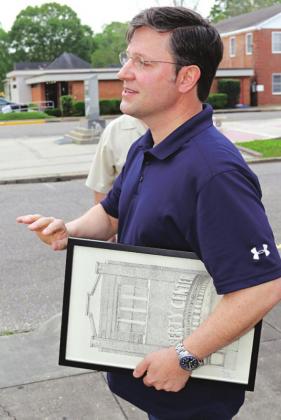 U.S. Rep. Mike Johnson is shown in Eunice on Friday holding artwork of the Liberty Theater presented to him by Zach Soileau, of Eunice. (Photo by Harlan Kirgan)