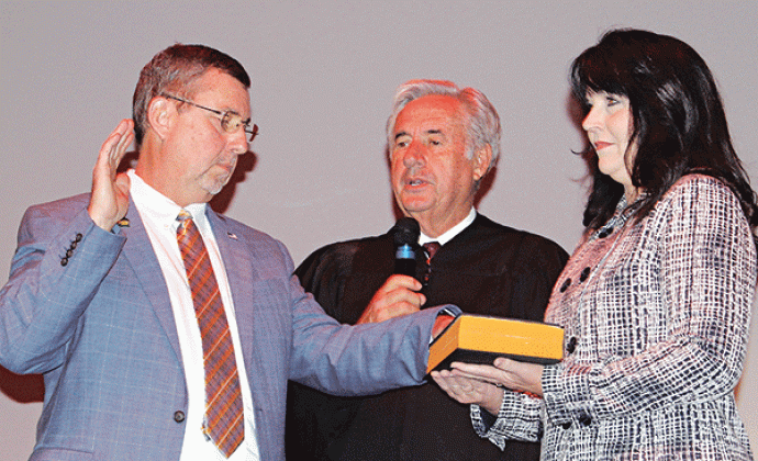 St. Landry Parish President Jessie Bellard, left, recites his oath delivered by Louisiana Associate Supreme Court Judge James Genovese and Bellard’s wife, Melissa, holds a bible.
