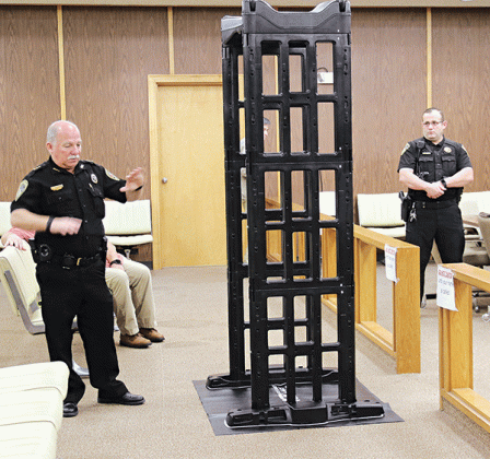 Eunice City Marshal Terry Darbonne, left, explains how a portable walk-through scanner works at a meeting Thursday in the Eunice City Court. At right is Chief Deputy Joey Peloquin. The meeting was to thank donors who helped pay for the scanner and 10 hand-held scanners. (Photo by Harlan Kirgan)