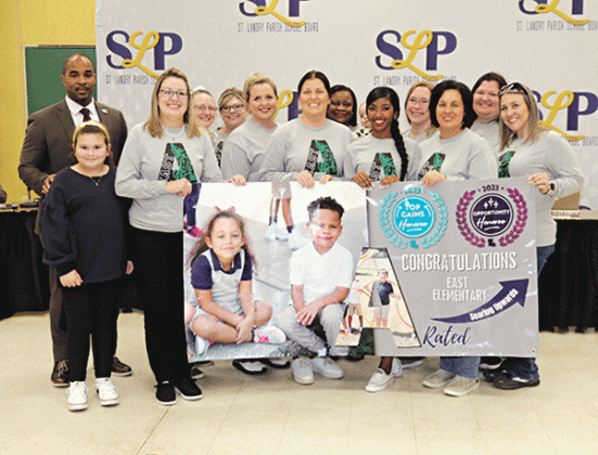 East Elementary in Eunice was recognized as an A-rated school in the state accountability scoring for 2023. A banner was presented to the school at Thursday’s St. Landry Parish School Board meeting. At left is Superintendent Milton Batiste. Holding the banner at left is Principal Gina LaGrange. Others in the photos are faculty members and their children. (Photos by Harlan Kirgan)