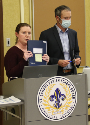 Tressa Miller, right, St. Landry Parish School Board finance director, holds an audit report up. At right is Casey Ardoin, CPA, of the Kolder, Slaven & Company. They were at the School Board’s Finance Committee meeting Monday in Opelousas. (Photo by Harlan Kirgan)