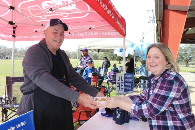 Ray Joubert at the First Baptist Church of Eunice booth at the first Church Jambalaya Cook-off serves a bowl of pork, beef and bacon jambalaya to Donna Lavergne Saturday. (Photo by Myra Miller)