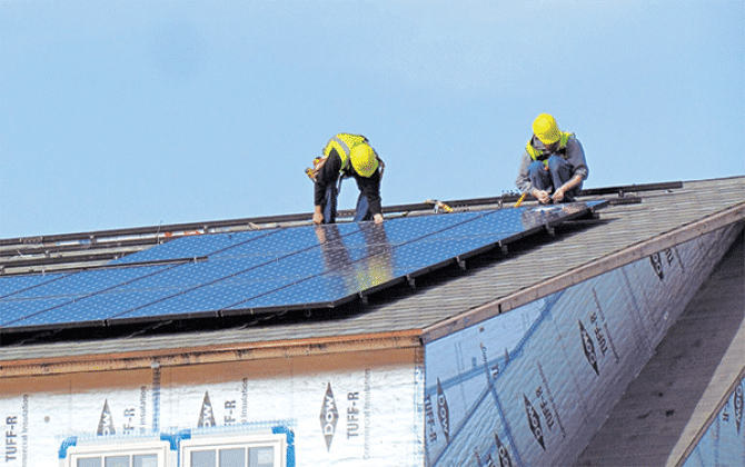 Workers install solar panels on the National Institute of Standards and Technology’s (NIST) Net-Zero Energy Residential Test Facility in Gaithersburg, Maryland. Solar for All, a federally funded program to provide rooftop and community solar to low-income residents, is on hold after President Donald Trump declared a freeze on funding climate-related projects and other spending. (Photo courtesy of NIST)