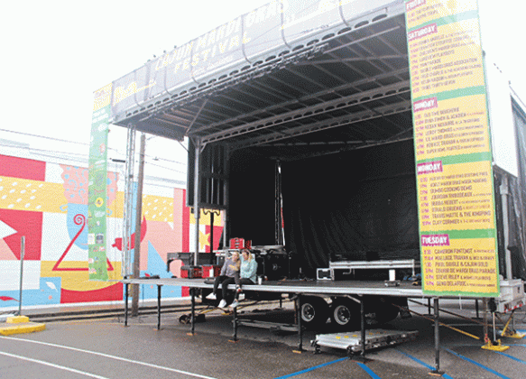 The music stage for the Eunice Cajun Mardi Gras Festival is at South 2nd Street and Walnut Avenue. Courtney Elkins, mayor’s assistant, and Alicia Mire, Main Street and tourism director, were seated on the stage Thursday afternoon. (Photo by Harlan Kirgan)