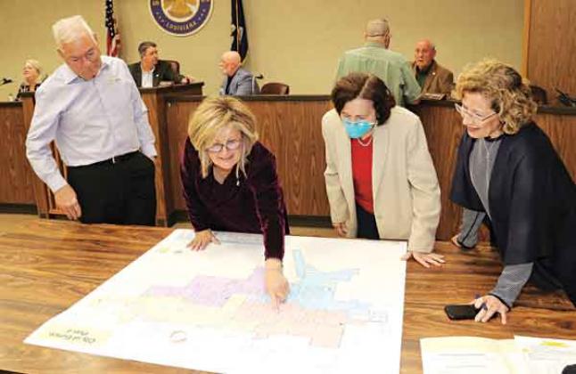 From left, demographer Mike Hefner, Alderwoman Connie Thibodeaux, Margaret Frey and Celeste Gomez look over the ward lines approved at Tuesday’s city meeting. The full map is on Page 12. (Photo by Harlan Kirgan)