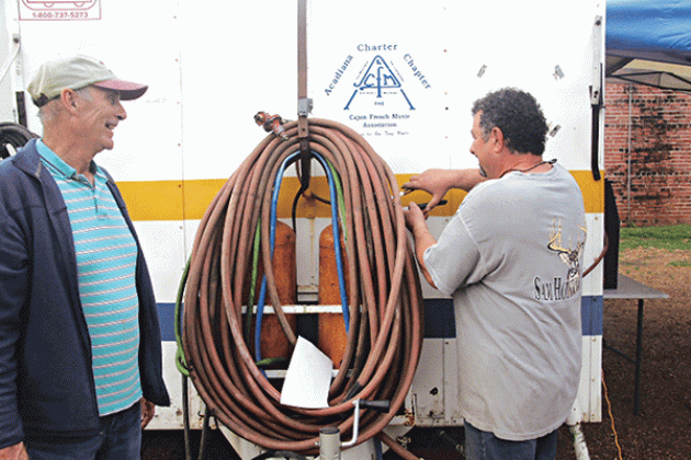 Charles Manuel, left, and Greg Brown, of the Acadiana Charter Chapter of the Cajun French Music Association, were among those working on a food site Thursday. (Photo by Harlan Kirgan)