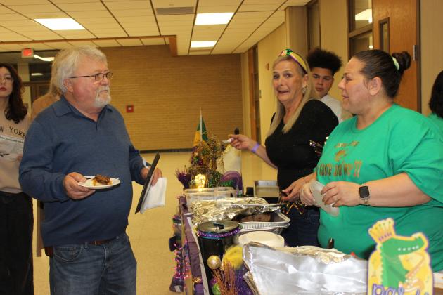 Terry Delasalle, of Montgomery, Texas, holds a sampling of meat loaf, gravy and mashed potatoes, provided by the Love Bonez crew during the 13th annual Taster’s Choice. Wilma Arnaud, left, and Tonya McGee assist Delasalle.
