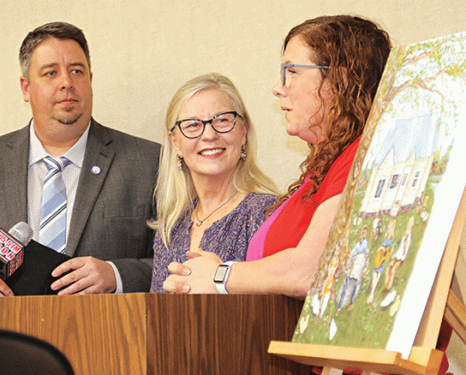 A painting by Eunice artist Amelia Vidrine was unveiled at the Eunice Board of Aldermen meeting on Feb. 14. The painting depicts the Dewey Balfa homestead is on a poster for the Dewey Balfa Cajun & Heritage Week set March 20 to 25 at Lakeview Park & Beach in Eunice. From left, are Mayor Scott Fontenot, Louisiana Folk Roots Director Jeanne Solis and Vidrine. (Photo by Harlan Kirgan)
