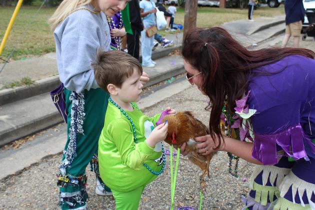 A young lad, a chicken and a Mardi Gras Reveler