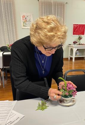 Joyce Johnson works on  her miniature flower arrangement.