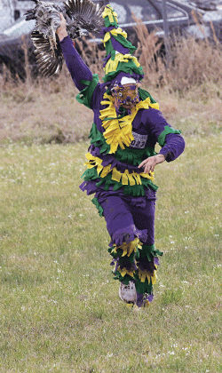 Hunter Aucoin holds a chicken aloft after catching it during the Eunice Mardi Gras Run. Aucoin was at the field at Parish Road 6-325 and North Bobcat Drive. (Photo by Harlan Kirgan)
