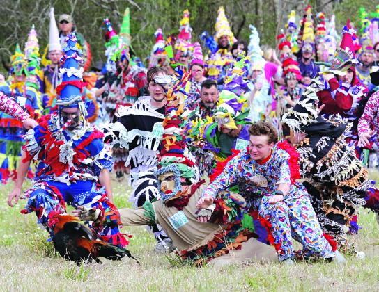 A rooster attempts to flee a frenzied pursuit by Mardi Gras runners Tuesday morning About 800 people registered for the run, according to Capitaine Pat Frey. Turn to Page 7 for more photos. (Photos by Harlan Kirgan)
