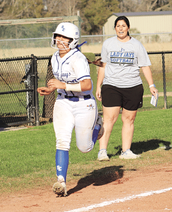 Maddie Evans is cheered on to home by Coach Nicole Lanthier after her 3-run homerun.