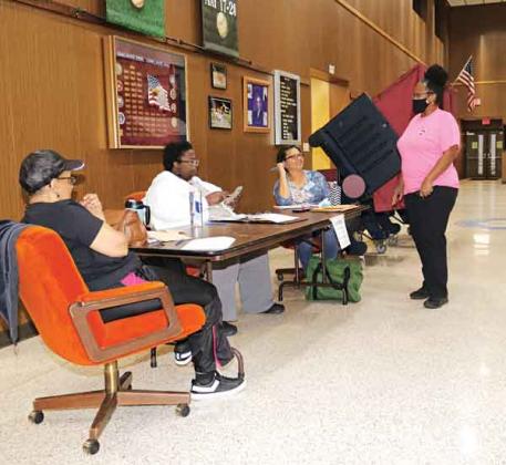 Voting was slow at the Eunice City Hall polling place. Stephanie Monte, standing right, was being redirected to vote at the Southeast Community Center at about 7:30 p.m. Saturday. Election workers, from left, are Theresa Guillory, Carla Frank and Sandra Wikins. (Photo by Harlan Kirgan)