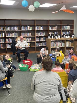 Police Chief Randy Fontenot reads to children at Story Time