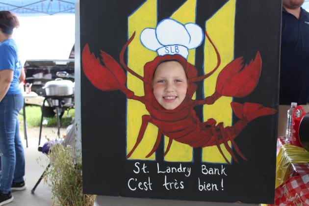 Hayden Jenkins, 7, placed her face in a wooden cut-out at St. Landry Bank &amp; Trust  cooking booth.