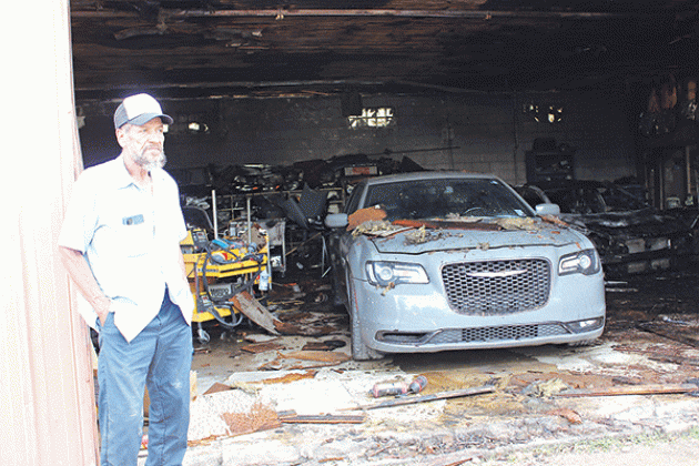 Kurn Semien, 70, stands by the fire-damaged paint and body shop he owns at 601 E. Laurel Ave., Eunice, on Tuesday. Fire damaged the shop on Monday. (Photo by Myra Miller)