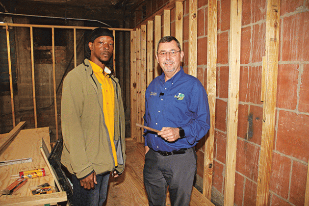 St. Landry Parish President Jessie Bellard, right, holds a piece metal that he and parish worker, John Rubin, said flew out of the wall to to the right and fell to the floor on Tuesday. “I wish I wouldn’t have seen it,” Rubin said on Thursday. Bellard said a group of people was in the former basement boiler room when the incident occurred. “We didn’t say long after that,” Bellard said. (Photo by Harlan Kirgan)