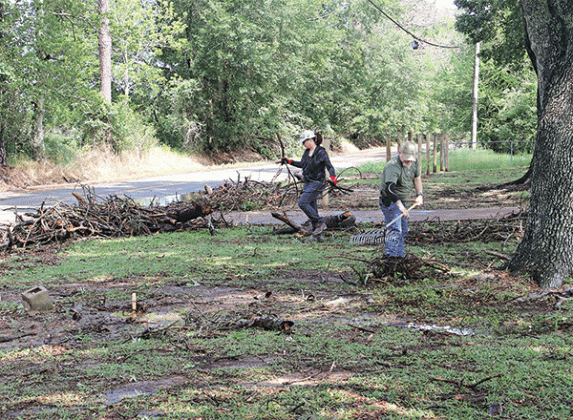 Sarah and Kevin Froehlich clean up storm debris from their property on Perchville Road near noon on Wednesday. (Photo by Harlan Kirgan)