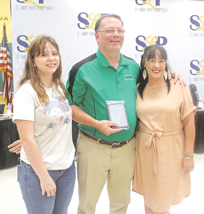 Kirt “Randy” Aguillard holds a plaque noting his 29 years as an educator during the May 1 St. Landry Parish School Board meeting. Aguillard, a teacher at Eunice High School, is retiring. From left, are Kaydie Oberste, Aguillard and Jackie Oberste.