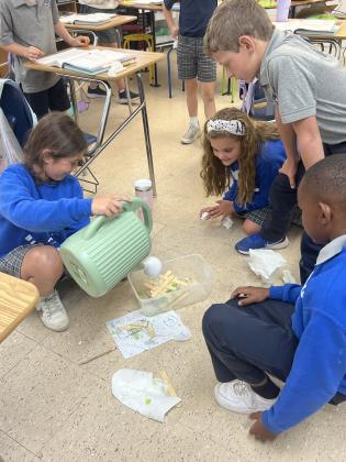 Abby Chapman’s third grade students at St. Edmund Elementary modeled an earthquake to understand how it could change an ecosystem and cause other natural hazards. From left are Mary Grace Brown, Lillian Habetz, Jax Vidrine and  Keith Reed.