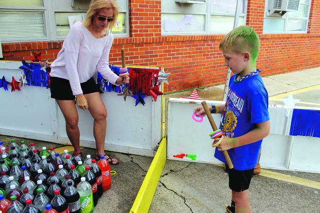 Davis Richard, 7, tries his luck at a ring toss game Saturday at the St. Edmund Spring Fair. Sarah Thomas is staffing the booth.