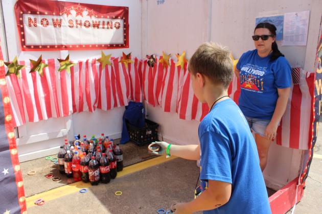Sam Vidrine, 8, tries his luck at a ring toss game at the St. Edmund Spring Fair Saturday. At far right is Mandy Ortego.