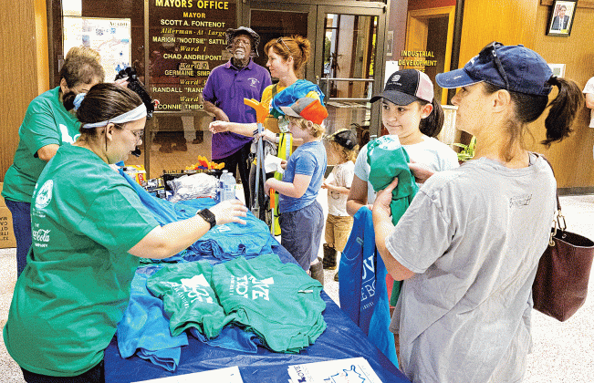 Volunteers pick up T-shirts and cleaning supplies on April 22 at the Eunice Municipal Complex lobby. (Photoo by David Simpson)
