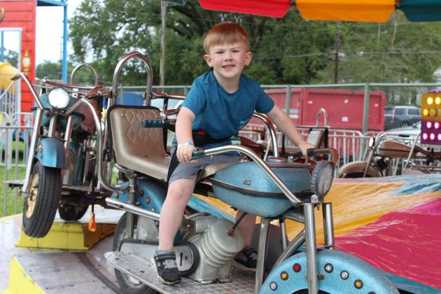 Maddox Rainville, 3, rides a motorcyle fair ride Saturday at the St. Edmund Spring Fair.