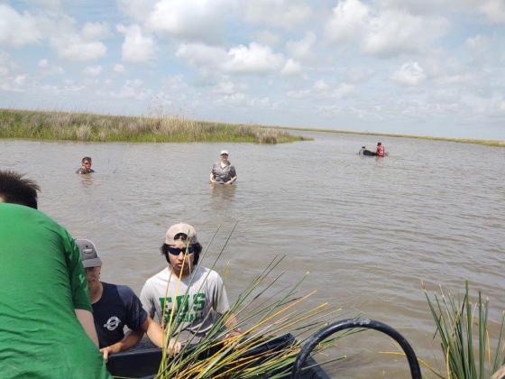 Carl Turk, Javier Deshotel and EHS Ag teacher Brooke Comeaux are waiting for more plants to be unloaded.