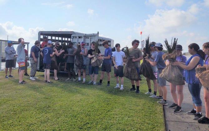 All the FFA Chapter members are seen moving the 5,500 plants from the trailer onto boats.