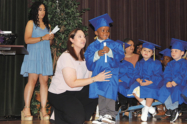 Dwight Allen Jr. receives his diploma from his teacher Johnette Dupre.