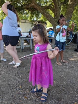 A little one, Rose Smith, in front, discovering the Hula Hoop.