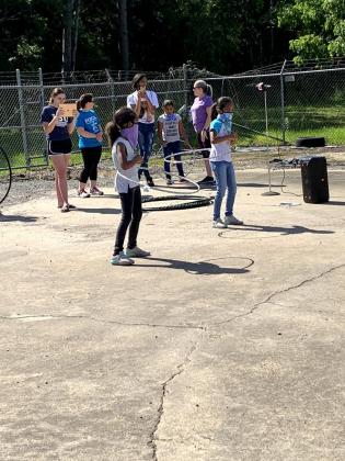In front are McKinley Douglas, left, and McKenzie Douglas, doing the Hula Hoop.
