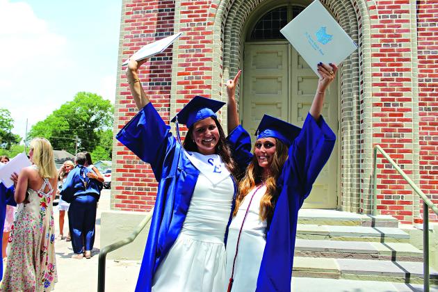 St. Edmund High graduating seniors Kennedy Dubroc, left, and Clara Brown celebrate after graduation ceremony outdoors.