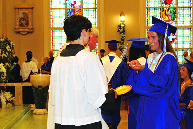 Jillian DeVillier receives Holy Communion during St. Edmund’s graduation Mass ceremony held Saturday morning.