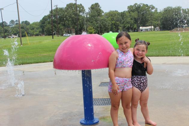 Cooling off at the Splash Pad at the Fairgrounds are Madisyn Brown, left, and Serenity Arnaud. The Splash Pad is opened everyday from 10 a.m. to 6 p.m.
