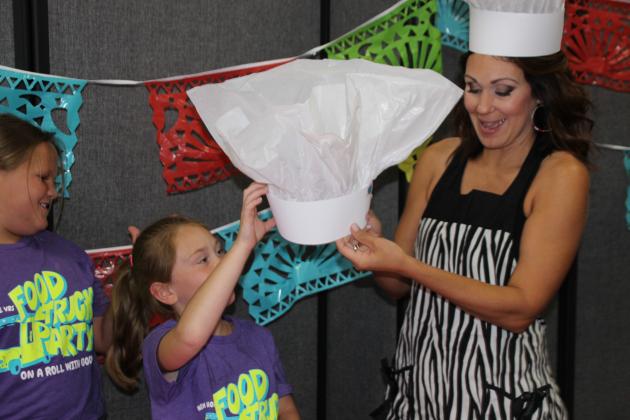 New Hope Fellowship held its Vacation Bible School this week from 9 a.m. until noon for children ages 4-11. The theme this year is, “Food Truck Party on a Roll with God!” Many children attended and enjoyed games and activities, arts and crafts, Bible songs and much more. Making a chef hat, from left, are  Rowynn Dietz, Sophia Rainville and Nicole Moreau, a VBS leader.