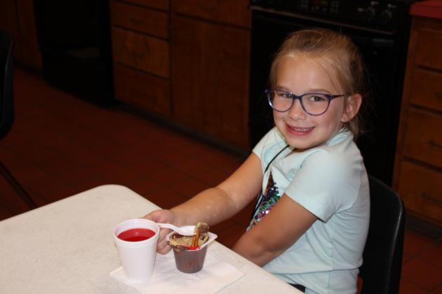 St. Thomas More Catholic Church held its Vacation Bible School this week with a theme, “Totally Catholic Monumental Celebrating God’s Greatness.” Many children enjoyed arts and crafts, skits, singing and dancing, outdoor activities and snacks. Allison Clark, 6, enjoyed a “Sandy Cup” made with chocolate pudding, graham cracker crumbs, pretzel stick and gummy worms.