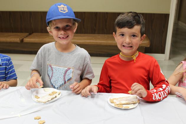 At Happy Days are Boston Brown, 5, left, and Walton Kora, 5. They are crafting their Graham cracker snack with vanilla icing and Teddy Grahams, placed on the top.