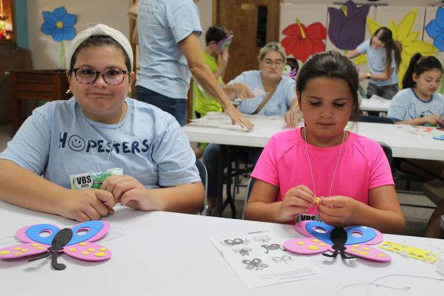 Ellie Guidry, left, and Ellie Deville are crafting a foam butterfly mask.