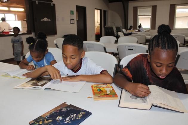 Reading time for these kids. From left are Islah Robinson, 4, Antonio Thomas, 9, and Brenlee Robinson, 9.