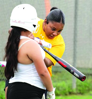 Gabby Mitchell, a LSUE Lady Bengals Softball player, instructs a summer camp participant during a practice drill. (LSUE Softball Facebook photo)