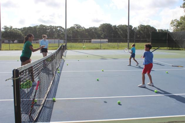 Eunice High tennis team instructors Mallory Thomas, left, and Destiny Labbe teach the basic skills of tennis to Kyren Gabriel, 6, and Laura Brown, 7,  during tennis camp sponsored by the Eunice Recreational Center.
