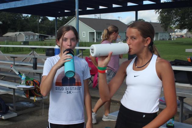 Taking a water break at tennis camp are left Audra Fontenot, 12, and Kynlie Floyd, 13.