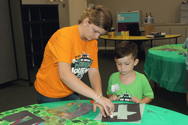 Marissa Stagg helps Gunner Ortego, 5, with a craft at Summer Surge held at New Hope Fellowship in Eunice. Kids enjoyed a summer camp this week with many fun activities, games, arts and crafts and more.