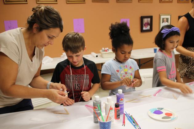 Meghan Darbonne, a leader, assists children with a fish craft during St. Anthony Church’s Happy Days held this week. The kids used wooden Popsicle sticks, paint, glue, markers to create their finished product. From left are Darbonne, Rylan Guidry, Khloe Glaze and Avery Richard. (Photo by Myra Miller)